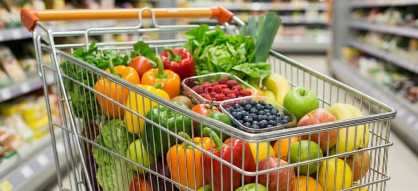 Caddie de supermarché rempli de fruits et légumes