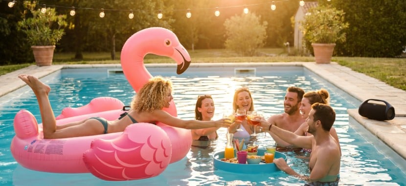 des adultes prennent l'apéritif dans une piscine
